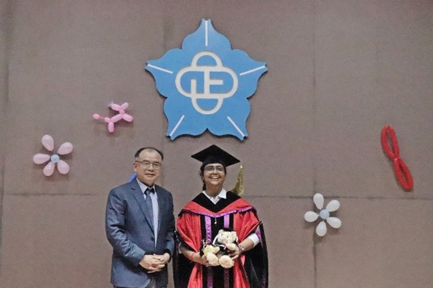 身穿學位服外國畢業生與陳建易教授於大禮堂合影
