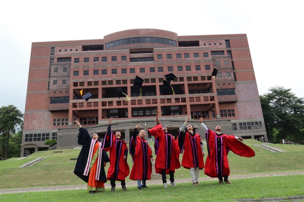 身穿學位服外國學生與陳建易教授於中正大學圖書館前的鳳凰大道合影(拋學士帽)